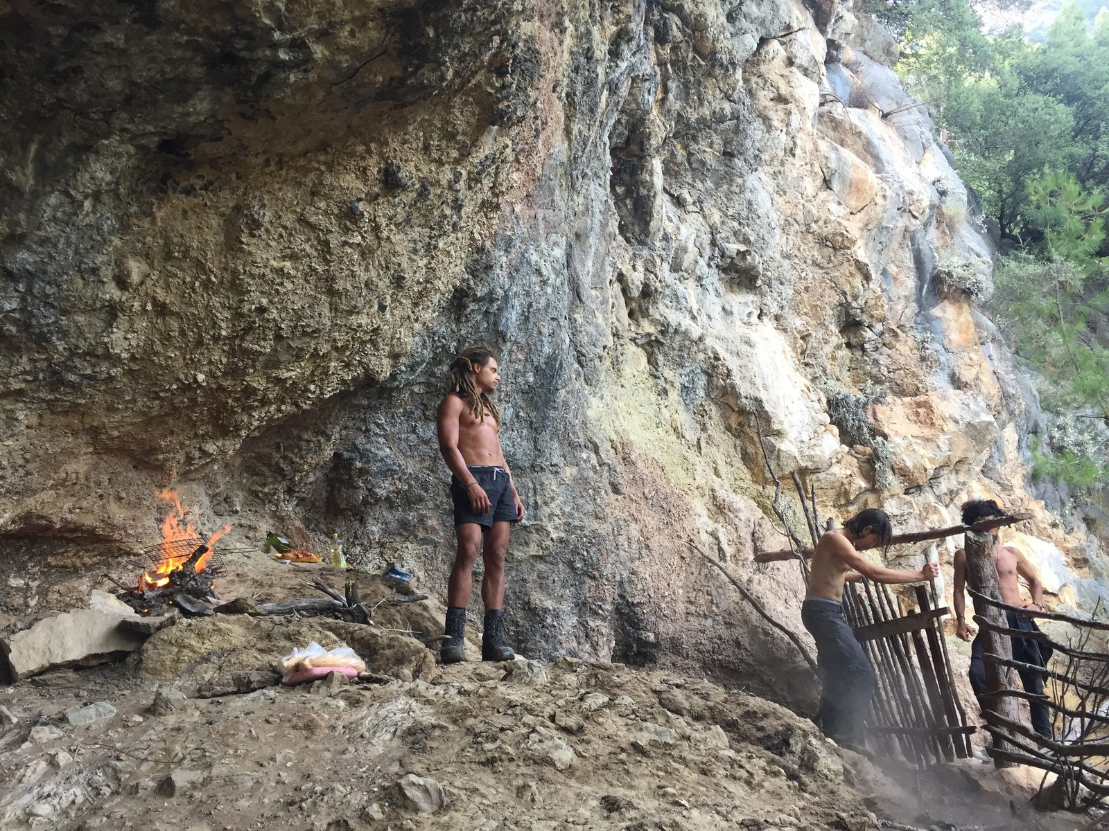 Living under a rock overhang in Turkey — fire, cliff face, simple camp